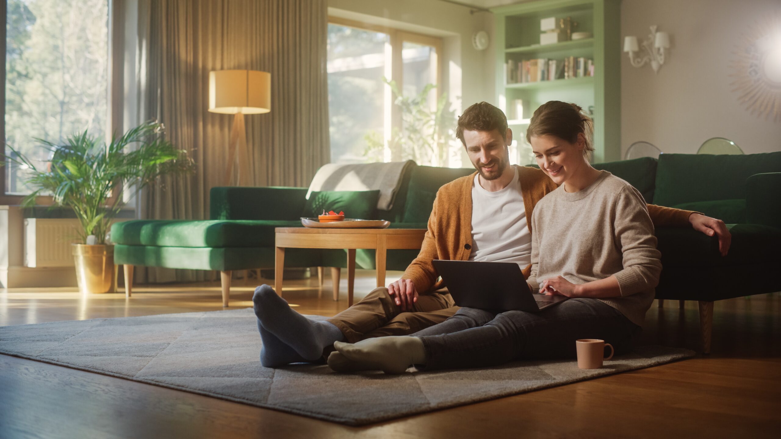 young homeowners at home checking interest rates on their phone